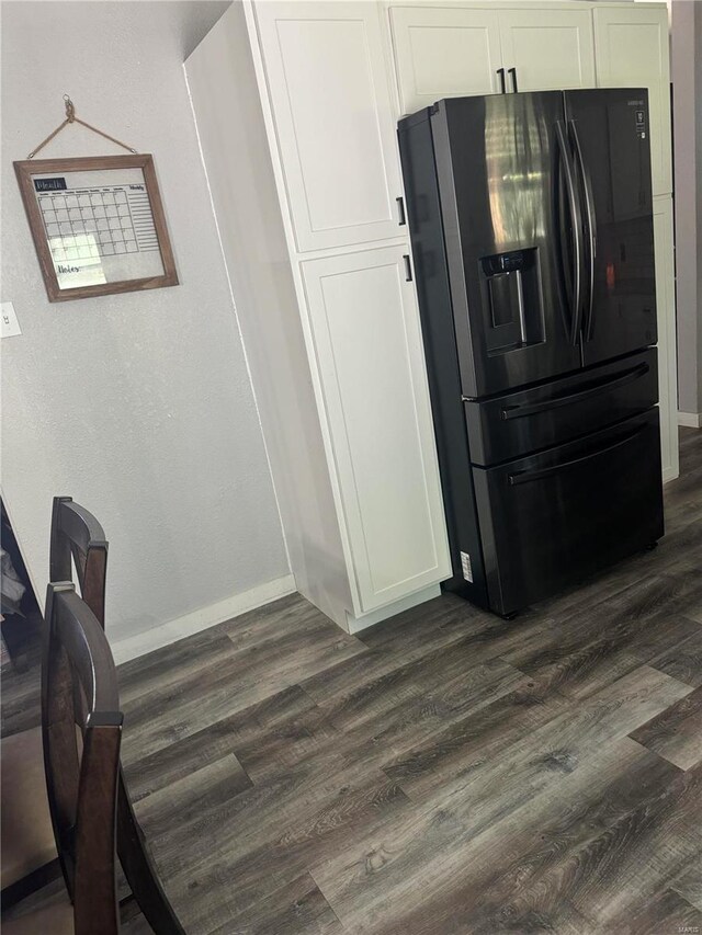 kitchen featuring black fridge with ice dispenser, dark hardwood / wood-style floors, and white cabinets