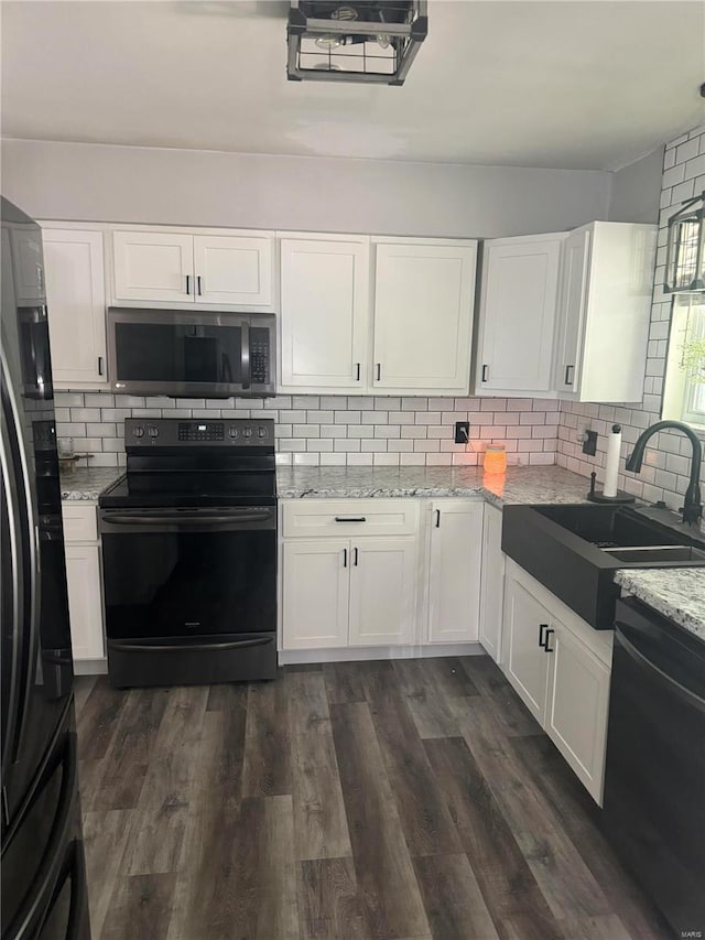 kitchen with sink, white cabinets, decorative backsplash, black appliances, and dark hardwood / wood-style flooring