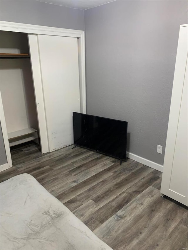 unfurnished bedroom with a closet and dark hardwood / wood-style flooring