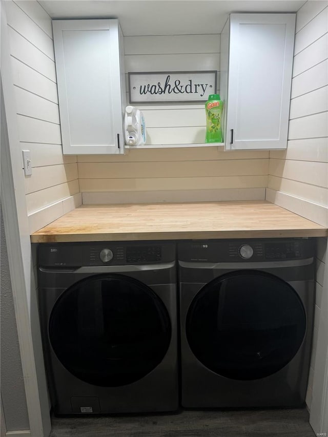 laundry area with washing machine and clothes dryer and cabinets