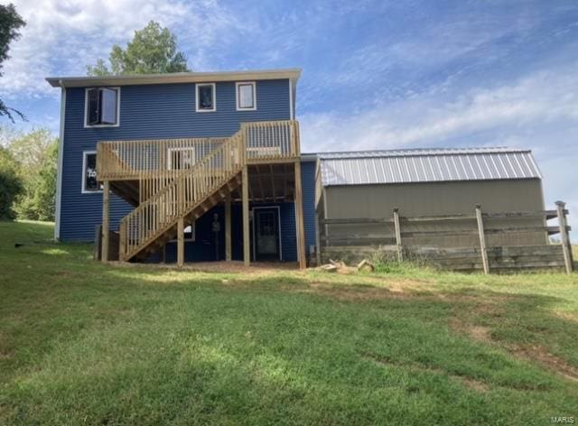 rear view of house with a wooden deck and a yard