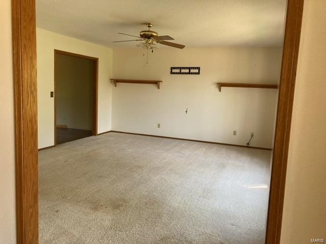 spare room featuring ceiling fan and carpet