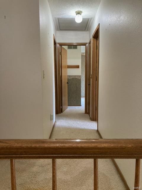 hall with a textured ceiling and carpet