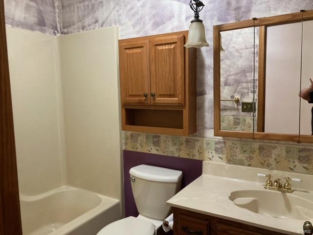 full bathroom with  shower combination, vanity, and toilet