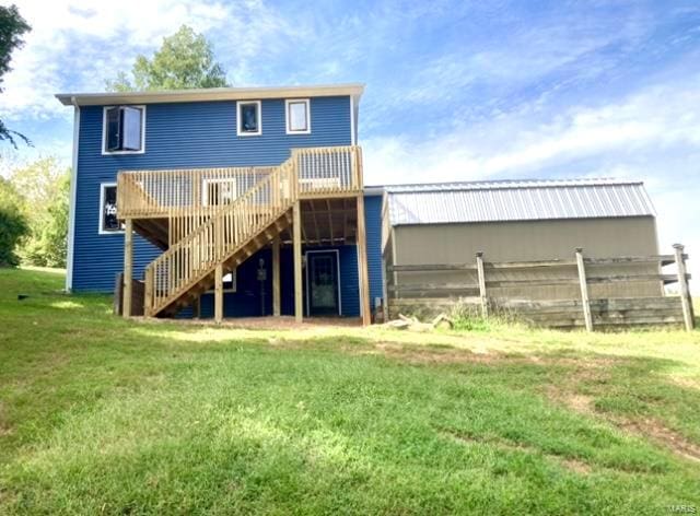 back of property with a lawn and a deck