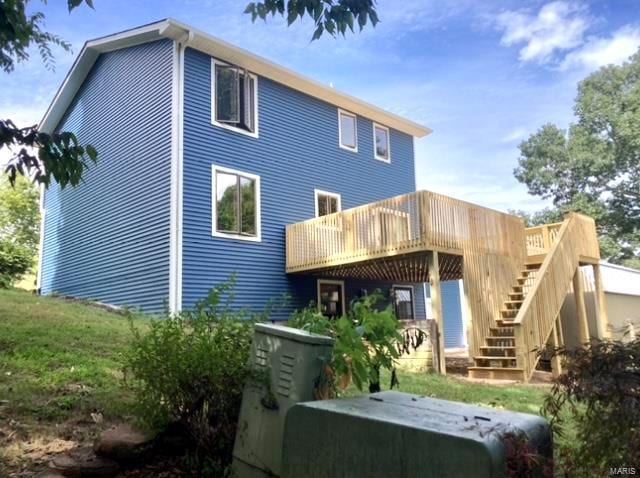 rear view of house featuring a wooden deck