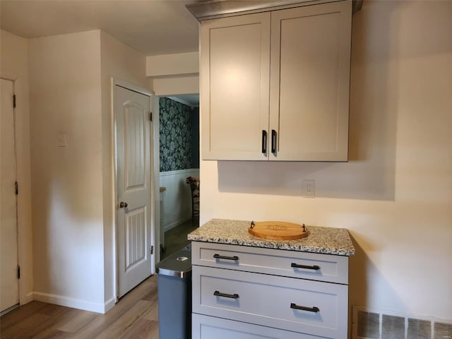 kitchen with light hardwood / wood-style flooring and light stone counters