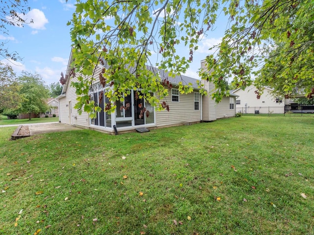 rear view of property with a lawn