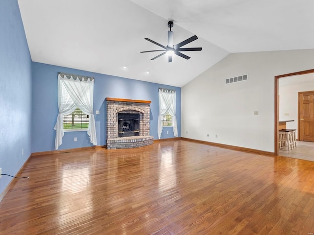 unfurnished living room featuring a fireplace, wood-type flooring, ceiling fan, and a healthy amount of sunlight