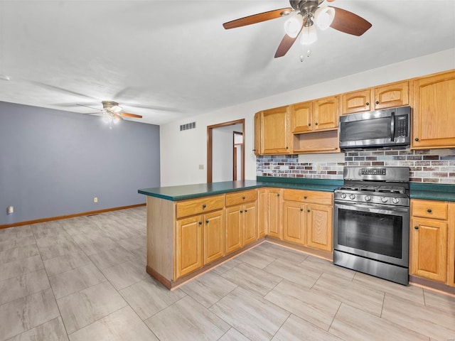 kitchen with tasteful backsplash, kitchen peninsula, ceiling fan, and stainless steel range oven