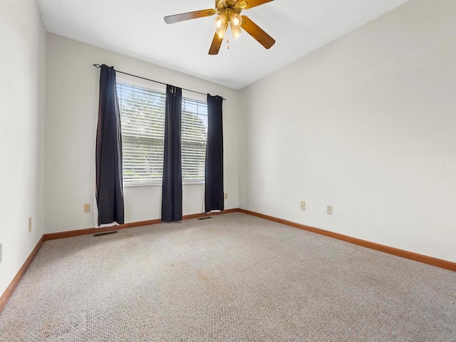 carpeted spare room featuring ceiling fan