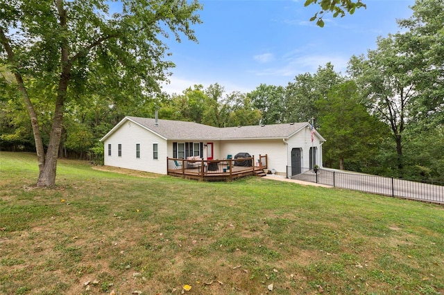 rear view of property featuring a yard and a deck