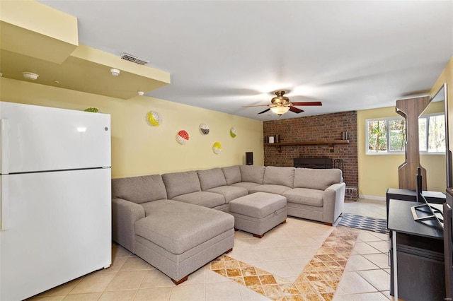 living room featuring ceiling fan, light tile patterned floors, and a fireplace