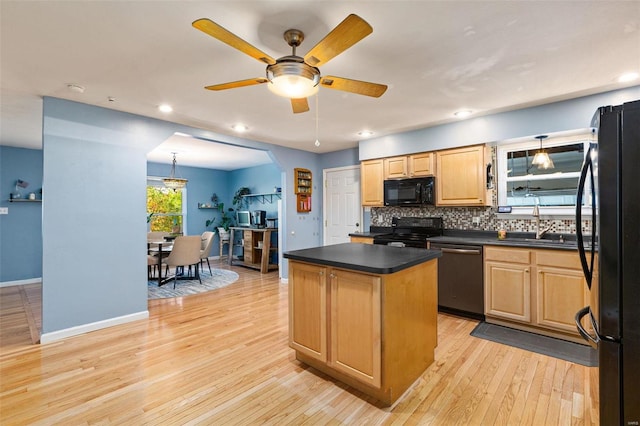 kitchen featuring backsplash, black appliances, a center island, light hardwood / wood-style floors, and ceiling fan