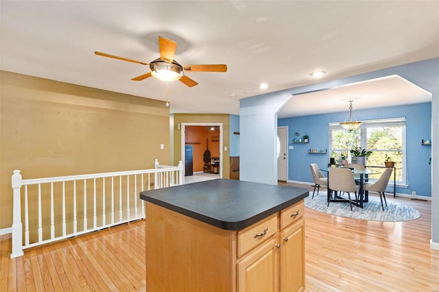 kitchen featuring light hardwood / wood-style flooring, hanging light fixtures, a center island, light brown cabinetry, and ceiling fan