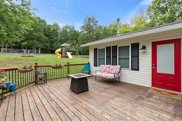 wooden terrace with a playground, a fire pit, and a yard