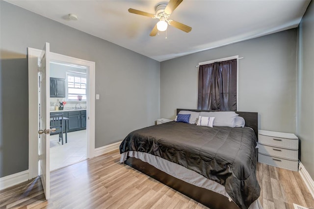 bedroom with light wood-type flooring, ceiling fan, and sink