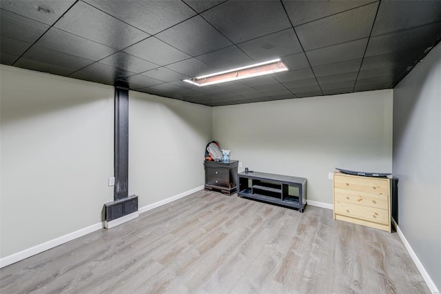 basement featuring a drop ceiling and light hardwood / wood-style floors