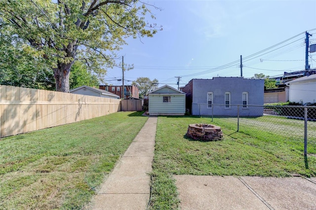 view of yard with a fire pit and a shed