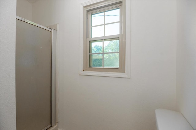 bathroom featuring toilet and an enclosed shower