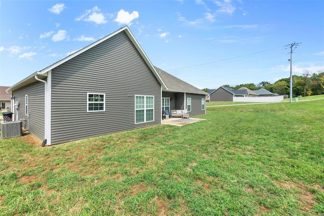 rear view of house featuring a patio, a lawn, and central air condition unit