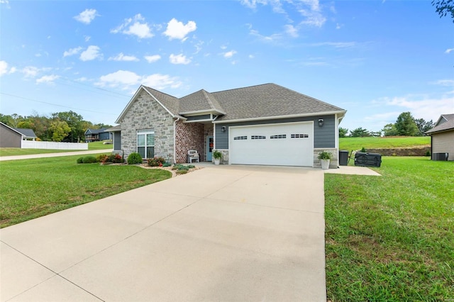 view of front of property with a garage, central AC unit, and a front yard