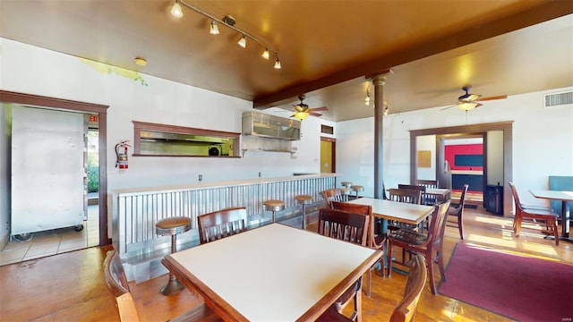 dining space with ornate columns, beam ceiling, light tile patterned floors, and ceiling fan