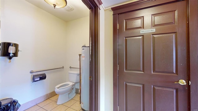 bathroom featuring water heater, toilet, and tile patterned floors