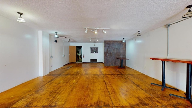 empty room with ceiling fan, hardwood / wood-style floors, and a textured ceiling