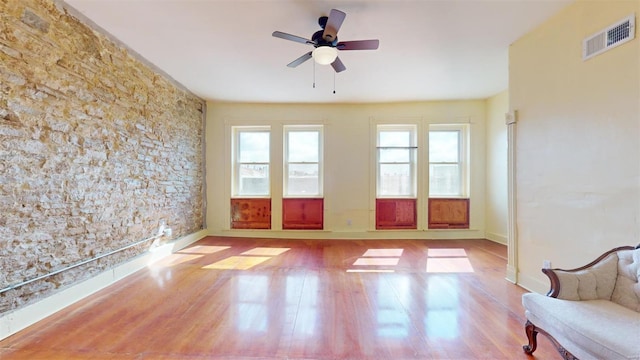 unfurnished sunroom with ceiling fan