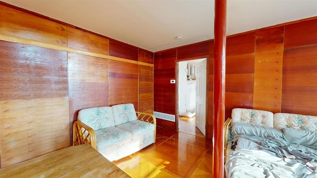 sitting room with wood-type flooring and wood walls