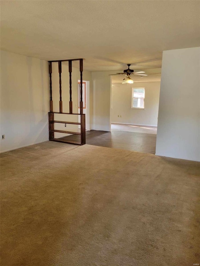 spare room with ceiling fan, a textured ceiling, and carpet