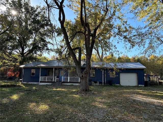 single story home featuring a porch, a front lawn, and a garage