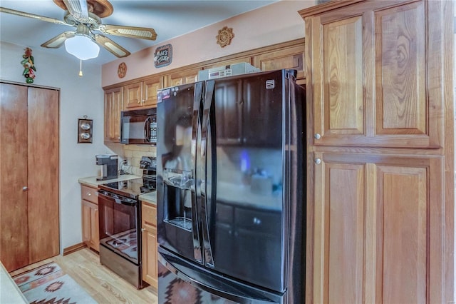 kitchen featuring light wood-type flooring, black appliances, ceiling fan, and tasteful backsplash