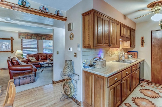 kitchen featuring tasteful backsplash, dishwasher, light wood-type flooring, ceiling fan, and sink