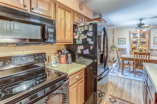 kitchen with ceiling fan, light hardwood / wood-style floors, tasteful backsplash, and black appliances