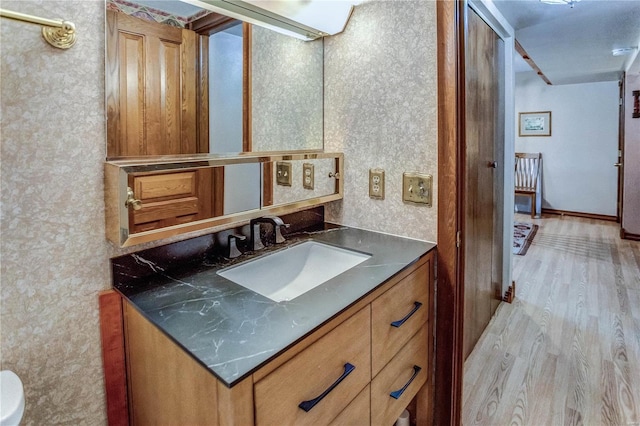 bathroom with vanity, toilet, and hardwood / wood-style flooring