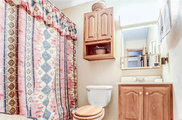 bathroom featuring walk in shower, vanity, and toilet