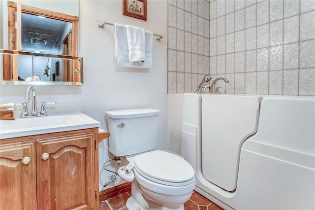 bathroom featuring a tile shower, vanity, tile patterned flooring, and toilet