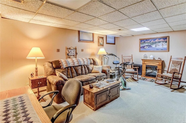 carpeted living room featuring a drop ceiling