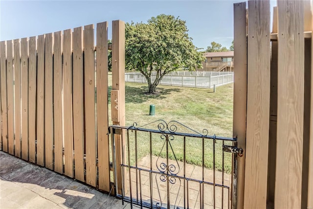 view of gate with a lawn