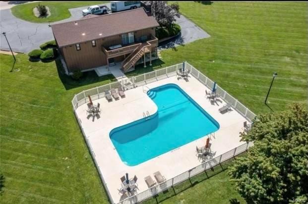 view of swimming pool featuring a deck, a lawn, and a patio area