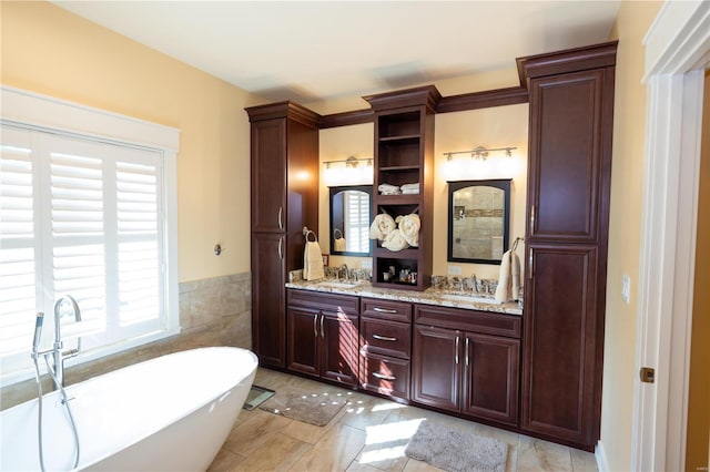 bathroom featuring vanity, a washtub, and tile patterned flooring