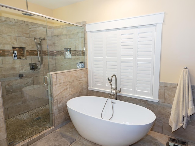 bathroom featuring tile patterned floors, tile walls, and separate shower and tub