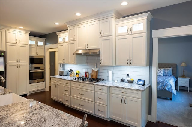 kitchen with white cabinetry, backsplash, stainless steel appliances, and dark hardwood / wood-style floors