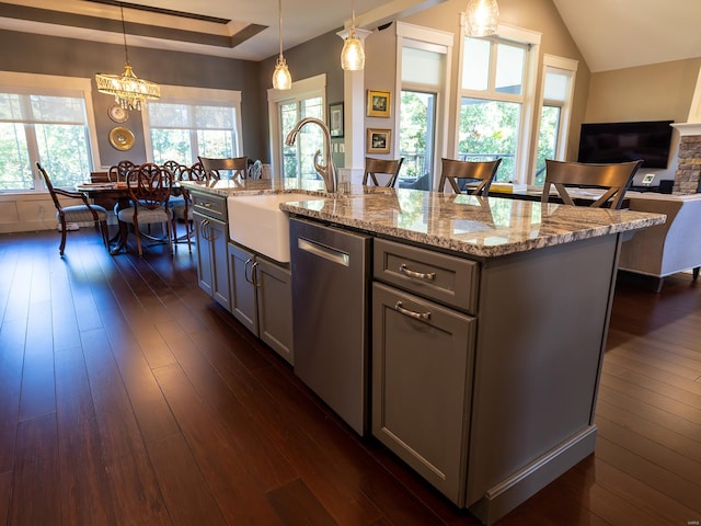 kitchen with dishwasher, a kitchen island with sink, dark hardwood / wood-style floors, hanging light fixtures, and sink