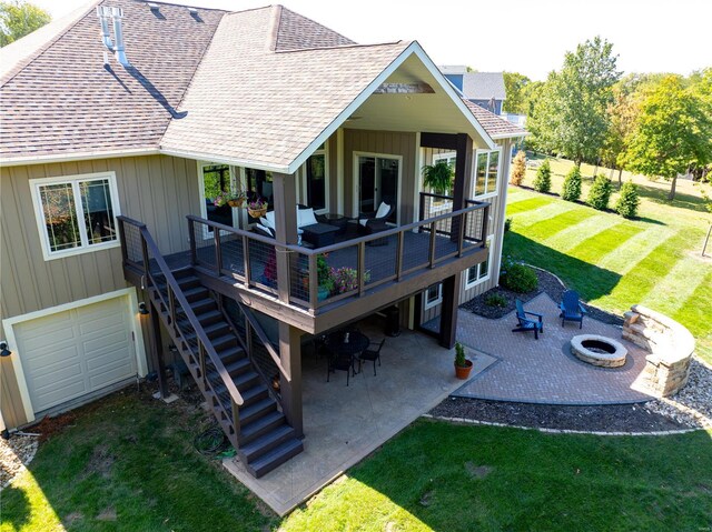 rear view of house featuring a patio, a wooden deck, an outdoor living space with a fire pit, and a lawn