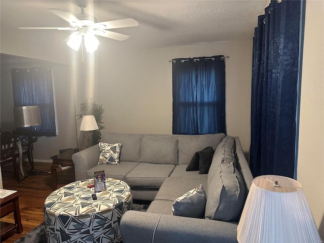 living room featuring ceiling fan, hardwood / wood-style floors, and a textured ceiling