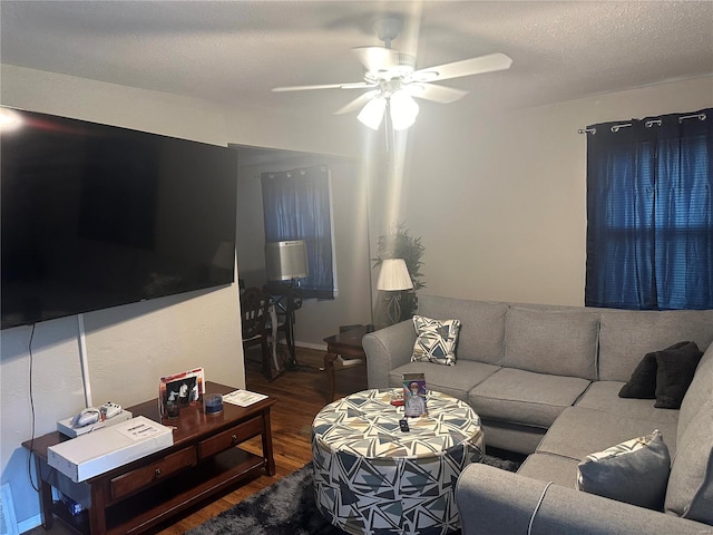 living room with a textured ceiling, dark hardwood / wood-style floors, and ceiling fan