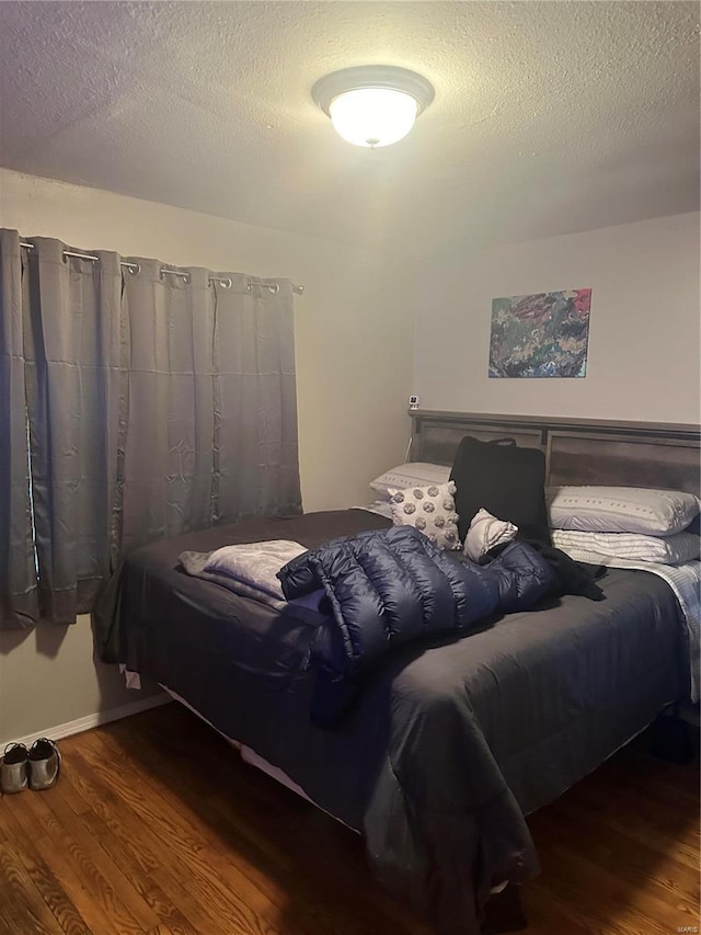 bedroom with a textured ceiling and hardwood / wood-style floors